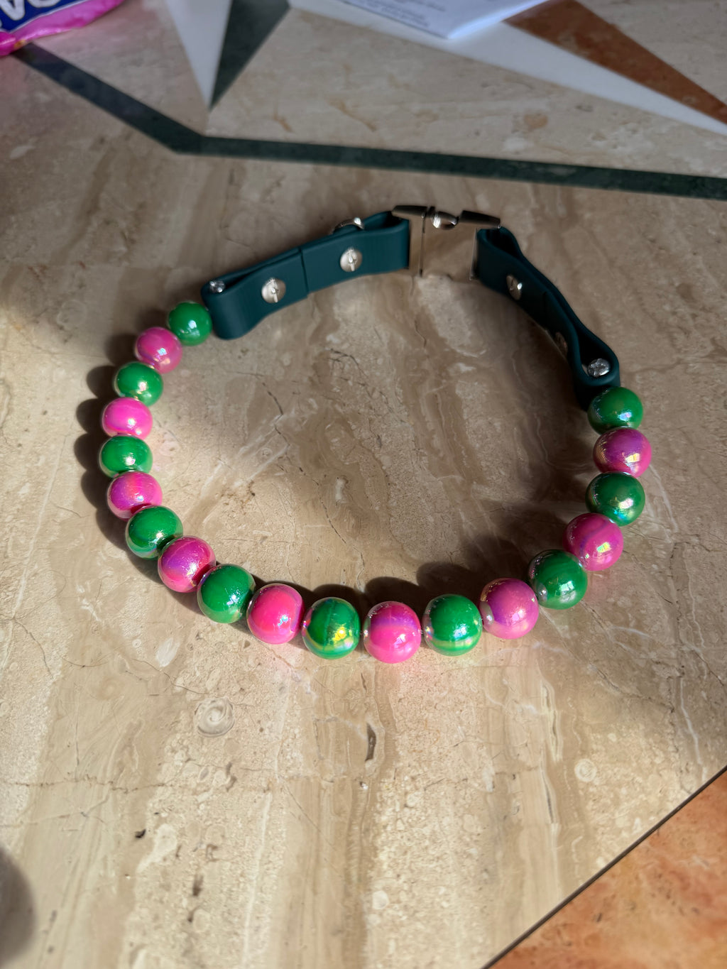Wicked Paws beaded dog collar - pink and green beads on wood surface